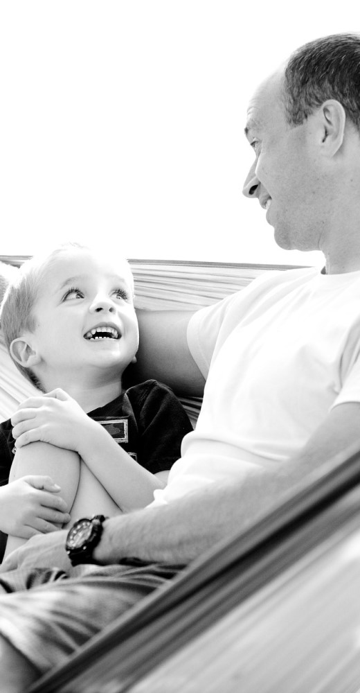 Vater mit Sohn sitzen zusammen in einer Hängematte